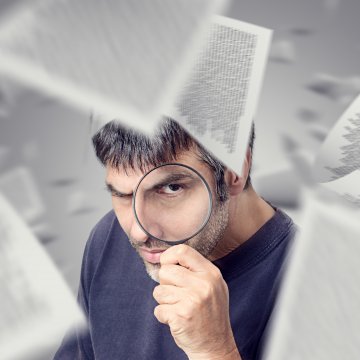 identity guard identity theft protection service review overview benefits man looking through magnifying glass papers flying all around him